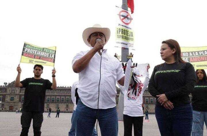 Activistas escalan el asta bandera del Zócalo para protestar contra la planta de amoníaco en Topolobampo
